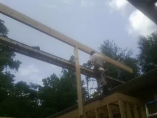 Carpenter setting a ridge beam over a new addition frame — Ice Dam Removal by Roofing Brothers in Sprague River