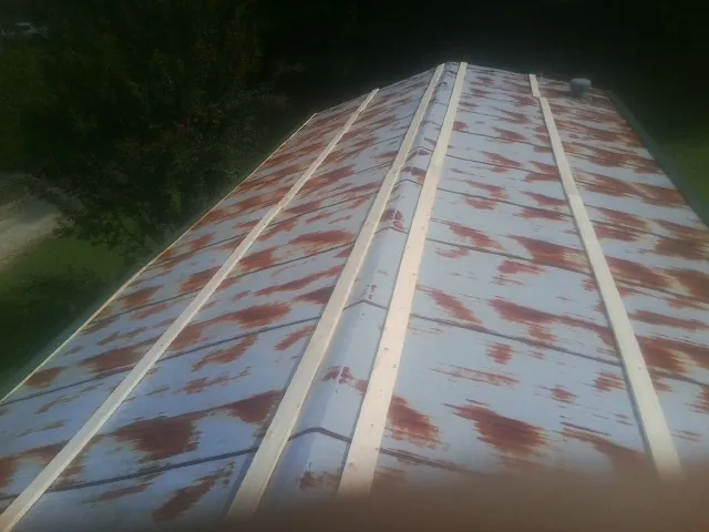 Rusted metal roof panels with new wood purlins before replacement — Storm Damage Roof Repair in Sprague River by Roofing Brothers
