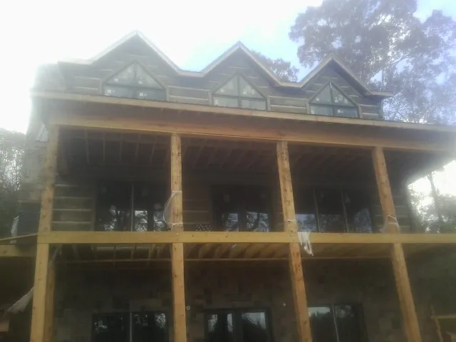 Dormers and porch framing on a large log home under construction — Roof Coating work by our crew in Sprague River