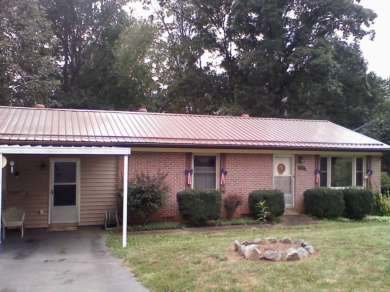 Bronze metal roof and carport on a brick ranch home — Roof Repair work by our crew in Sprague River